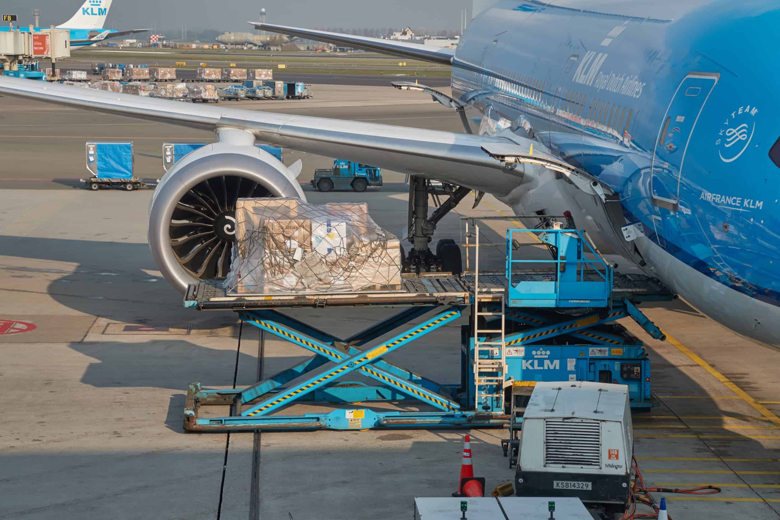Cargo being loaded onto a KLM passenger plane at the airport.